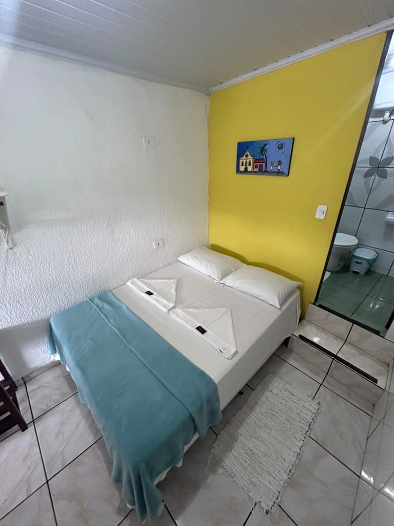 Quarto duplo amarelo com cama de casal