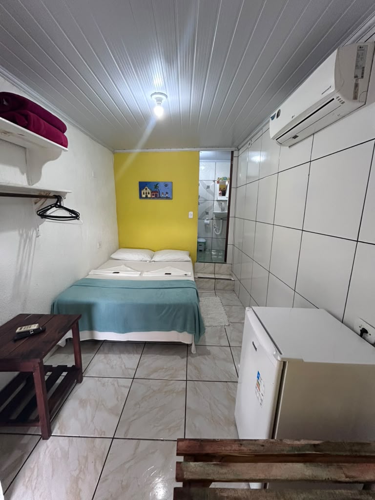 Quarto duplo amarelo com frigobar e banheiro