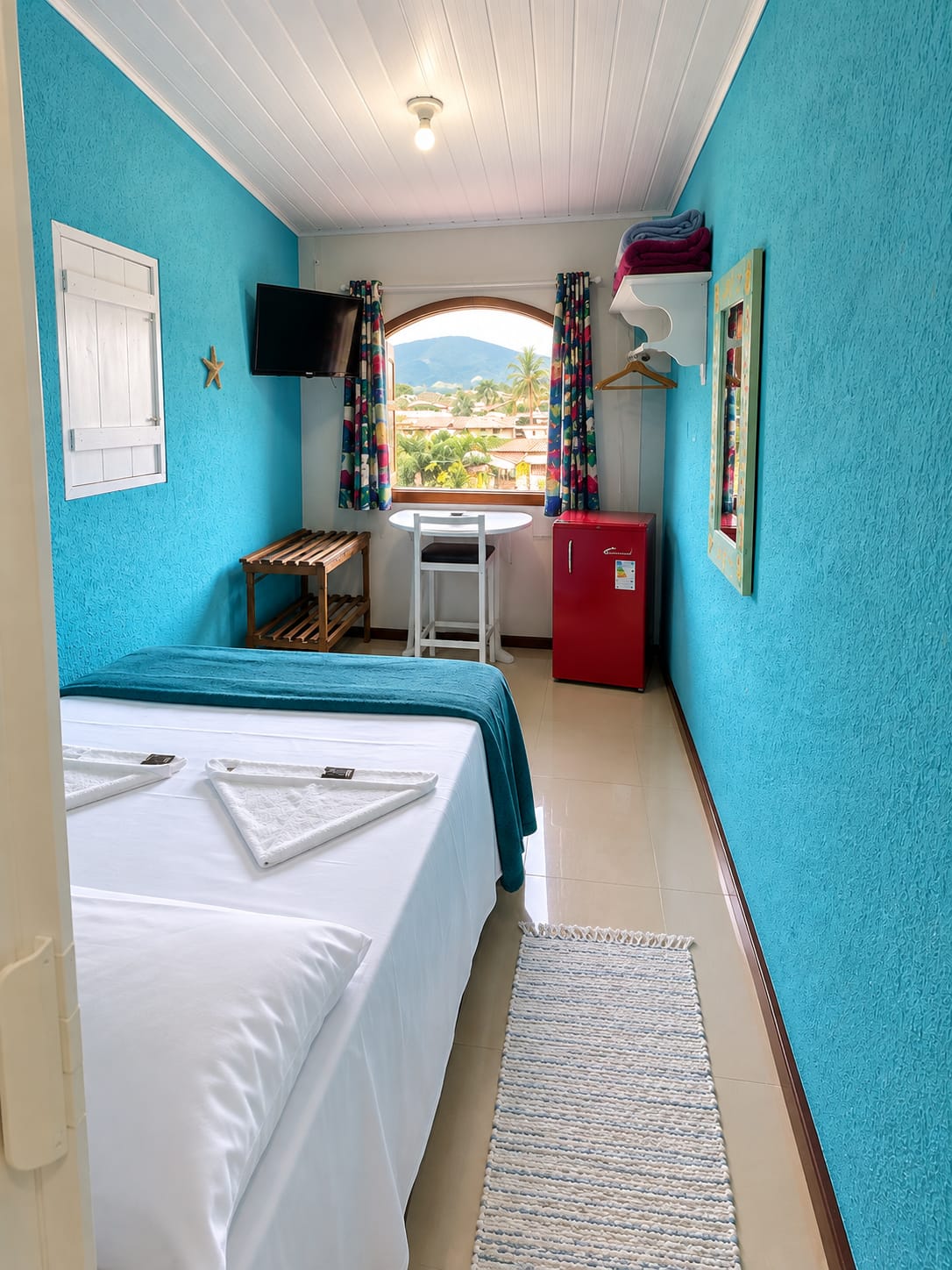 Suíte azul com janela panorâmica